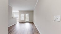 This contemporary 820 square foot apartment offers a thoughtfully designed living space with two bedrooms and one bathroom. The open-concept layout seamlessly integrates the kitchen, living, and dining areas, creating a spacious feel. The kitchen boasts white cabinetry, contrasting black appliances, and a practical breakfast bar.

Both bedrooms feature ample space, with the primary bedroom measuring 150 square feet. Each room is equipped with ceiling fans and large closets. The bathroom showcases a clean, modern design with a tub/shower combination.

The apartment's aesthetic is defined by its neutral color palette, with light gray walls complementing the warm-toned vinyl plank flooring throughout. Crown molding adds a touch of elegance to the space. Large windows in the living area and bedrooms allow for plenty of natural light.

A standout feature is the in-unit laundry room, complete with full-sized washer and dryer. The apartment also includes three closets for additional storage. Located in The Colonnade complex at 4100 Central Pike in Hermitage, TN, this unit offers a blend of comfort and convenience in a desirable location.