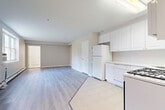 Located at 7112–7312 John F. Kennedy Blvd E in North Bergen, NJ, this well-designed single-floor unit offers a clean, modern aesthetic with a neutral color palette and light wood-look flooring running throughout the main living areas. The entrance opens into a bright hallway lined with multiple closets — four in total — providing exceptional storage rarely found in comparably sized units. The open-concept living, dining, and kitchen area forms the heart of the space, offering a flexible layout that maximizes functionality. The kitchen is outfitted with white cabinetry, white appliances including a refrigerator, dishwasher, gas range, and microwave, and is finished with light ceramic tile flooring that transitions seamlessly into the main living space. A large window in the living area allows natural light to fill the room, and a baseboard heating system and wall AC unit ensure year-round comfort. The bathroom is a standout feature, finished with striking marble-style floor and wall tile, a soaking tub with shower, and a white vanity with mirrored medicine cabinet. The overall ambiance is bright, clean, and move-in ready, offering a practical and comfortable living environment.