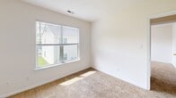 Located at 3824 Maplefield Drive in Chesapeake, Virginia, this single-floor, 2-bedroom, 1-bathroom home offers a practical and well-organized layout. The kitchen features warm honey-toned wood cabinetry, stone-patterned countertops, a stainless steel sink, and black appliances including a dishwasher and range, all set atop durable wood-look flooring. A separate dining room and living room provide distinct spaces for daily living and entertaining. Both bedrooms are carpeted and bathed in natural light from large windows with neighborhood views, giving each room a bright, airy feel. The textured ceilings and clean white walls throughout lend the home a simple, neutral aesthetic. The bathroom is equipped with a full soaking tub and shower combination finished in white, complete with a grab bar and curtain rod. Ample storage is available through five closets distributed across the home, along with a dedicated pantry and laundry area. A hallway connects the main living spaces efficiently. The clean, move-in-ready condition of the home, combined with its well-defined room layout, makes it a comfortable and functional residence in the Chesapeake area.