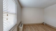 Located at 189 Wallace Rd in Nashville, TN, this efficiently designed studio unit makes smart use of its compact footprint across a single floor. Light-toned laminate wood flooring runs throughout the space, lending warmth and continuity to every area.

The main living area features neutral, light-gray walls that create a clean and airy atmosphere. Natural light enters through a window fitted with horizontal blinds, while a wall-mounted HVAC unit ensures year-round climate control. The entry door is a classic paneled design that opens directly into the living space.

The kitchen is thoughtfully appointed with dark espresso cabinetry, a white countertop, a single-basin sink, and a stainless steel electric range. A stylish mosaic tile backsplash in gray and white tones adds a contemporary decorative touch, complementing the under-cabinet range hood above.

The bathroom is bright and clean, finished in white with a combined tub and shower unit, a toilet, and a vanity. Chrome fixtures add a polished look throughout.

A dedicated closet provides valuable storage, while a smart thermostat panel on the wall adds a modern convenience. This unit offers a practical and well-maintained living space well-suited for those seeking a streamlined lifestyle in the Nashville area.