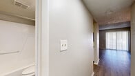 Located at 919 Ballard St in Altamonte Springs, Florida, this single-floor unit offers a straightforward and functional layout designed for comfortable everyday living. Throughout the space, wood-look laminate flooring provides a clean, cohesive aesthetic that runs from the main living area through the hallway and into the bedroom.

The living area is open and well-proportioned, featuring neutral beige walls, white baseboards, and a textured popcorn ceiling. A louvered closet door adds classic detail, while a pass-through window connects the living space directly to the kitchen, enhancing the open feel. The kitchen is laid out in a galley style, equipped with white cabinetry, light-toned laminate countertops, a black electric range with overhead ventilation, and a stainless steel refrigerator — all set on matching wood-look flooring.

A hallway with overhead lighting leads toward the private areas of the unit, including a spacious bedroom bathed in natural light from a large window. The bedroom features the same warm flooring and neutral walls, offering a calm and restful environment.

The bathroom includes a full tub and shower combination with chrome fixtures and a built-in grab bar, a toilet, and a vanity with storage. Ventilation is provided via ceiling vents throughout. The overall ambiance is clean, neutral, and move-in ready.