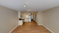 Located at 2000 Walnut St in the heart of Boulder, Colorado, this single-floor unit offers a thoughtfully designed open layout that seamlessly connects the living area and kitchen. The space features light hardwood flooring throughout, lending warmth and continuity from room to room.

The kitchen is outfitted with stainless steel appliances, including an electric range, built-in microwave, and refrigerator. White cabinetry provides ample storage, while a clean countertop and sink complete the functional workspace. Track lighting runs along the ceiling, providing excellent illumination across the kitchen and living areas.

The main living area is bright and open, benefiting from natural light streaming in through a set of windows along one wall. A baseboard heating system ensures year-round comfort. Neutral beige walls throughout the unit create a clean, versatile backdrop ready for personalization.

The hallway connects the main living space to additional rooms, including a bathroom featuring a tiled tub and shower combination, a toilet, and a frosted privacy window that brings in soft natural light. The overall layout makes efficient use of space, offering a comfortable and functional environment.

Situated in vibrant Boulder, CO, this unit combines practical amenities with a clean, modern aesthetic in one of Colorado's most desirable cities.