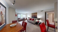 This single-story residence offers a thoughtfully designed layout that seamlessly connects its primary living spaces. The open-concept living and dining area serves as the heart of the home, featuring carpet flooring, crown molding, and a wood-burning fireplace framed by a white mantel and large mirror. Natural light enters through multiple windows dressed with sheer and panel curtains, creating a bright and welcoming atmosphere. The living room provides generous space for seating and entertaining, while the adjacent dining area accommodates a full table and chairs with ease.

The kitchen features rich cherry-toned cabinetry, granite countertops, hardwood-style flooring, and stainless steel appliances, with a breakfast bar offering additional seating. Track lighting enhances both functionality and ambiance.

Two well-proportioned bedrooms each feature plush carpet, large windows with outdoor views, and ceiling fans for added comfort. The primary bedroom includes an en-suite bathroom, while both bathrooms are finished with granite-topped vanities, rich wood cabinetry, and bright vanity lighting. The overall design maintains a cohesive, warm aesthetic throughout the residence.