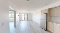 Located at 11701 W Gateway Blvd in West Los Angeles, this thoughtfully designed one-bedroom, one-bathroom unit offers a clean, contemporary aesthetic throughout. Light-toned luxury vinyl plank flooring runs seamlessly across the entire space, complementing the crisp white walls and creating a bright, airy atmosphere.

The open-concept living and dining area is flooded with natural light, highlighted by a sliding glass door that leads to a private balcony with views of surrounding greenery. The modern kitchen is a standout feature, outfitted with light wood flat-panel cabinetry, white subway tile backsplash, quartz countertops, and a full suite of stainless steel appliances including a gas range, microwave, dishwasher, and refrigerator.

The bedroom is a comfortable, well-proportioned retreat featuring a wide picture window with horizontal blinds that frame outdoor views and fill the room with natural light. A sliding door closet provides convenient built-in storage with a full hanging rod.

The bathroom is sleek and functional, featuring a tub and shower combination enclosed by a frameless sliding glass door, with white subway tile surround and brushed nickel accents. A hallway connects the main living areas, completing the efficient and well-organized floor plan of this move-in-ready West LA residence.