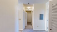 Located at 100 Crimson Rose Dr in Huntsville, Alabama, this single-floor, 2-bedroom, 2-bathroom home offers a thoughtfully arranged layout designed for comfortable everyday living. The open living room features neutral-toned walls, plush carpet flooring, and a seamless connection to the kitchen via a raised breakfast bar with pendant lighting overhead. The kitchen is efficiently designed with light wood cabinetry, ample counter space, and white appliances including a range, refrigerator, microwave, and dishwasher, all set on durable tile flooring. Both bedrooms are carpeted and include ceiling fans with integrated lighting. The generously sized primary bedroom offers a walk-in closet outfitted with multi-level wire shelving and hanging rods for organized storage. The second bedroom benefits from a window that invites natural light. Each bathroom features a tub-shower combination, tile flooring, a vanity with sink, and a mirror. A dedicated laundry area houses a full-size washer and dryer. A hallway with louvered closet doors, carpet flooring, and an accessible electrical panel provides added functionality. The interior throughout maintains a clean, neutral palette with white trim and textured ceilings.