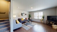 This multi-story residence is thoughtfully designed across three floors, offering a cohesive blend of modern finishes and functional living spaces. The living area serves as the heart of the home, featuring warm wood-style plank flooring, neutral gray walls, and a generously sized window fitted with white blinds that allow natural light to fill the room. The open layout provides a comfortable and versatile setting for both relaxing and entertaining.

The kitchen is well-equipped with rich dark cabinetry, granite-style countertops, and a full suite of stainless steel appliances, including a gas range, over-the-range microwave, and dishwasher. A window above the sink adds additional brightness to the space.

The bedrooms feature soft wall-to-wall carpeting and standard closets, providing a quiet and comfortable retreat. Each room includes a window for natural light and ventilation. The bathrooms are finished with granite-topped vanities, dark cabinetry, large mirrors, and a clean white soaking tub with brushed nickel fixtures.

Overall, the residence presents a consistent design aesthetic throughout, combining practical amenities with contemporary finishes suited for everyday living.