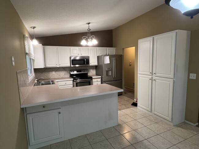 Kitchen with fridge, range, microwave and dishwasher - 6811 Balsam Ln N