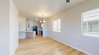 Located at 2700 Pierce Pkwy in Springfield, Oregon, this well-designed single-story residence offers four bedrooms and two full bathrooms across a thoughtfully laid-out floor plan. Light hardwood-style flooring flows consistently throughout the home, creating a clean, cohesive aesthetic.

The open-concept kitchen and living area serves as the heart of the home. The kitchen features light wood cabinetry with matte black hardware, white quartz countertops, a stainless steel undermount sink, and a full suite of black appliances including a refrigerator, range, microwave, and dishwasher. A peninsula with additional counter space connects the kitchen to the living area, which is brightened by a chandelier and a window with plantation shutters.

The spacious primary bedroom stands out with dual windows, a ceiling fan with light fixture, a wall-mounted HVAC unit, and a private door leading to an outdoor balcony with views of the surrounding landscape. The additional bedrooms are bright and functional, each featuring hardwood-style flooring and windows that bring in natural light.

Both bathrooms are finished with warm wood vanities, white countertops, black hardware accents, and eye-catching patterned tile flooring in a classic motif, complemented by a tub-shower combination. Hallways connect the rooms efficiently, and a dedicated closet provides additional storage throughout this clean, modern home.