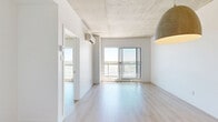 Located at 625 Avenue de l'Equinoxe in Brossard, this well-appointed one-bedroom, one-bathroom unit offers a thoughtfully designed layout across a single floor. The open-concept living and kitchen area forms the heart of the space, bathed in natural light from large sliding glass doors that lead to a private balcony overlooking open surroundings. A wall-mounted mini-split unit ensures year-round climate comfort in the living area.

The kitchen is a standout feature, showcasing a generous island with a warm stone-toned countertop, an undermount sink, and light wood cabinetry. Stainless steel appliances — including a refrigerator, electric range, and dishwasher — are seamlessly integrated, with track and pendant lighting completing the modern aesthetic.

The bedroom is a bright, quiet retreat with a large window framing outdoor views and exposed concrete ceiling details that add an industrial character consistent throughout the unit. Light wood-tone flooring flows continuously through all rooms, enhancing the sense of openness.

The bathroom is clean and functional, featuring large-format tile flooring, a floating wood vanity with a white countertop, and a full bathtub with shower. A dedicated closet provides practical storage. The overall design is minimal, modern, and cohesive.