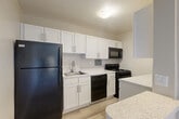 Located at 1201 S Courthouse Rd in Arlington, Virginia, this one-bedroom, one-bathroom residence offers a well-organized layout across a single floor. The combined living and dining area is a bright, open space anchored by a wide, multi-pane window that fills the room with natural light and frames views of the surrounding Arlington neighborhood. Plush wall-to-wall carpeting and neutral-toned walls create a clean, inviting atmosphere throughout the common areas.

The kitchen is thoughtfully designed with white shaker-style cabinetry, speckled stone countertops, and light wood-tone flooring. Black appliances — including a gas range, over-the-range microwave, dishwasher, and refrigerator — provide a sharp contrast against the bright cabinetry, offering a functional and visually distinct cooking space.

The generously sized bedroom features soft carpeting, a large window with outdoor views, and ample closet storage, including a double sliding-door closet. Three closets total are distributed throughout the unit, providing excellent storage options. The bathroom is finished with classic white subway tile, a tub/shower combination, and a wall-mounted vanity mirror. The unit's neutral palette and consistent finishes make it a practical and comfortable home in a prime Arlington location.