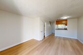 Located at 1106 Prospect in Santa Rosa, CA, this two-story residence offers a well-organized layout spread evenly across two floors. The main level features an open living and dining area finished with light hardwood-style flooring and textured ceilings, creating a bright and airy atmosphere. Sliding glass doors allow natural light to fill the living space and provide access to an outdoor patio area. The galley-style kitchen is efficiently designed with warm wood cabinetry, dark countertops, stainless steel appliances including a gas range, dishwasher, and refrigerator, plus a stainless sink — maximizing functionality within a compact footprint. A convenient bathroom on the main floor features a unique angled ceiling detail, wood-tone cabinetry, and hardwood-style flooring. Carpeted stairs lead to the upper level, where two bedrooms provide comfortable retreats, each with plush carpet flooring, closets, and windows offering views of surrounding greenery. The primary bedroom is a well-proportioned space with ample natural light. Two additional bathrooms, including a full bath with a soaking tub, serve the upper level. Utility rooms and hallways complete the practical layout of this efficiently designed two-story home.