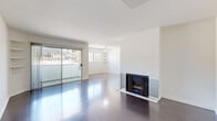 Located in the desirable West Hollywood neighborhood of Los Angeles, this well-designed one-bedroom, one-bathroom residence offers a thoughtful layout across a single floor. The open living room is a standout, featuring rich dark hardwood floors, a classic fireplace with tile surround, and a ceiling fan overhead. Built-in shelving adds functional character to the space, while large sliding glass doors open to a balcony that frames views of the surrounding Los Angeles hillside. Abundant natural light fills the room throughout the day. The kitchen is efficiently designed in a galley configuration, outfitted with warm wood cabinetry, granite countertops, tile flooring, and stainless steel appliances including a gas range and refrigerator. The spacious primary bedroom continues the hardwood flooring and includes a mirrored sliding-door closet, with a window offering additional natural light and outdoor views. The bathroom features tile flooring, a wood vanity with granite countertop, and a tub-shower combination. Clean white walls throughout the residence create a bright, neutral backdrop, lending the space a fresh and modern ambiance ideal for comfortable city living.