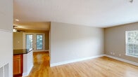 Located at 1981 Randolph Pl in Winchester, VA, this one-bedroom, one-bathroom unit offers a well-designed, single-floor layout that makes efficient use of its space. The open-concept kitchen and living area serves as the heart of the home, where warm hardwood flooring flows throughout. The kitchen is equipped with stainless steel appliances — including a range, microwave, and dishwasher — complemented by rich dark granite countertops, a breakfast bar peninsula, and natural wood cabinetry that provides ample storage. Recessed lighting brightens the space, while a ceiling fan in the adjoining living area adds comfort. Large windows allow natural light to fill the living room, offering pleasant outdoor views. The bedroom features soft wall-to-wall carpeting and multiple windows that bring in additional natural light and greenery views, creating a calm and restful atmosphere. A dedicated closet provides practical storage. The bathroom is clean and functional, appointed with white tile flooring, a full tub and shower combination, a white vanity, and recessed lighting. A utility area with two panel doors accommodates additional storage or mechanical access. Neutral warm-toned walls throughout lend the unit a cohesive, move-in-ready feel.