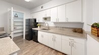 Located at 2530 Yorktown St in Houston's desirable Galleria/Uptown neighborhood, this single-floor unit offers a thoughtfully designed layout with consistent wood-look flooring flowing throughout every room, creating a cohesive and polished aesthetic.

The open living area is bright and airy, featuring large windows with horizontal blinds that invite natural light. A separate dining area is highlighted by an elegant multi-bulb chandelier and wainscoting detail along the wall, adding a refined architectural touch. An additional living or flex space includes ceiling fan lighting and full-length sliding glass doors with vertical blinds that open to a private outdoor area with greenery views.

The kitchen is well-appointed with crisp white shaker cabinetry extending to the ceiling, granite-style countertops, a stainless steel sink, and black appliances including a refrigerator and dishwasher. A pantry provides generous additional storage.

The bedroom is comfortably sized, featuring a ceiling fan, a window with natural light, and direct access to an adjoining room. The bathroom is cleanly finished with white cabinetry, granite countertops, a large mirror, and a tub-shower combination with marble-style surround tile.

Throughout the unit, neutral gray-white walls and clean trim work contribute to a bright, modern ambiance.