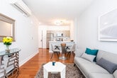 Located at 69 Academy St in Dover, NJ, this well-appointed single-floor residence offers a thoughtfully designed layout with modern finishes throughout. Warm hardwood flooring runs continuously across the living areas, bedrooms, and kitchen, creating a cohesive and inviting atmosphere.

The living room is bright and comfortable, featuring large windows dressed with horizontal blinds that allow ample natural light to fill the space. The room offers generous space for seating and relaxation, with a cozy, contemporary feel.

The kitchen is efficiently designed with a galley-style layout, showcasing light wood cabinetry with sleek hardware, white quartz countertops, a stainless steel undermount sink, and a full suite of stainless steel appliances including a refrigerator, range, and over-the-range microwave.

The bedrooms are serene and well-proportioned, each featuring soft gray walls, hardwood flooring, and windows with horizontal blinds that provide natural light and privacy. The rooms offer a calm, restful ambiance suitable for comfortable living.

The bathroom is clean and modern, with light stone-look tile flooring, white walls, a wood-toned vanity with a white countertop, and a crisp, minimalist design that complements the overall aesthetic of the home.