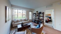 This single-floor, two-bedroom, two-bathroom unit is thoughtfully laid out to maximize functionality and comfort. The living area is bright and welcoming, featuring hardwood-style flooring and large windows that frame outdoor green space views, allowing generous natural light throughout the day. The space flows directly into the kitchen, which is equipped with light wood cabinetry, white appliances including a full-size refrigerator, a double sink, and a peninsula island with seating for casual dining — a practical and social focal point of the space.

Both bedrooms are carpeted and comfortably sized, each offering closet storage. The primary bedroom includes a window with outdoor views, while the second bedroom similarly benefits from natural light. Each of the two full bathrooms features a tub-shower combination, a vanity with wood cabinetry, white countertops, and stone-look tile flooring, providing a clean and consistent aesthetic.

A dedicated in-unit laundry area houses a full-size washer and dryer with overhead shelving for added storage. Throughout, the unit maintains a neutral color palette and a straightforward, functional design suitable for everyday living.