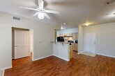 Located at 200 Long St in Slidell, Louisiana, this 2-bedroom, 2-bathroom single-floor home offers a well-organized layout designed for comfortable everyday living. The open-concept living and dining area flows seamlessly into the kitchen, which features a peninsula with granite-style countertops, a double-basin sink, light wood cabinetry, and black appliances including a refrigerator, range, and dishwasher. Rich hardwood-style flooring runs throughout the main living areas, complemented by neutral-toned walls and ceiling fans that enhance the bright, airy ambiance. Natural light enters generously through multiple windows fitted with blinds. The primary bedroom is a well-proportioned retreat with plush carpeting, a ceiling fan, and a window offering a view of the surrounding greenery. The second bedroom mirrors this comfort with carpet flooring, natural light, and its own ceiling fan. Both bathrooms are finished with light wood vanity cabinetry, granite-style countertops, tub-shower combinations with tile surrounds, and hardwood-style flooring. A dedicated closet and hallway provide additional storage and connectivity throughout the home. The layout is practical and efficient, making thoughtful use of the available space.