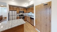 Located at 3847 28th St SW in Grandville, Michigan, this single-floor unit offers a thoughtfully designed layout with modern finishes throughout. The kitchen serves as a functional centerpiece, featuring warm-toned wood cabinetry, granite countertops, and a full suite of stainless steel appliances including a refrigerator, electric range, over-the-range microwave, and dishwasher. A peninsula with a granite surface provides additional prep and serving space, complementing the kitchen's practical design.

The living area is generously proportioned, with plush carpeting, recessed lighting, and windows that bring in natural light. The bedrooms are carpeted and well-sized, with one bedroom featuring a double-door closet with built-in shelving, and another benefiting from dual windows that offer pleasant outdoor views.

Two bathrooms serve the unit, both finished with granite-topped wood vanities and durable wood-look vinyl flooring. The full bathroom includes a tub-shower combination, while the second bathroom features a window for natural ventilation.

A dedicated utility and laundry room houses a full-size washer and dryer alongside a water heater, adding everyday convenience. Throughout the unit, warm wood-tone baseboards and doors tie the spaces together, creating a cohesive and functional living environment.