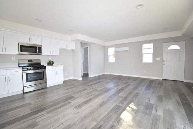 Living Room / Kitchen. Half Bathroom to the Left. - 7305 Ensign Ave