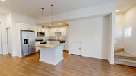 Located at 9105 Tredinick Pkwy in Jacksonville, FL, this two-story home offers a thoughtfully organized layout spread across two floors. The main level welcomes you through a dedicated entrance that opens into a bright, open-concept living area where the dining room, kitchen, and living room flow seamlessly together. Warm wood-look flooring runs throughout the main floor, complemented by white walls and recessed lighting. The kitchen is a standout feature, boasting white shaker cabinetry, granite countertops, stainless steel appliances, a central island with pendant lighting, and a ceiling fan in the adjoining living space. A large sliding glass door on the main level allows abundant natural light and outdoor views. A garage with an automatic opener provides convenient interior access. Upstairs, the second floor hosts both bedrooms, including a primary suite with a walk-in closet outfitted with wire shelving. The bedrooms feature plush carpeting, ceiling fans, and windows with neighborhood views. Three bathrooms are distributed across both floors, each finished with granite vanities and wood-look flooring. Additional highlights include three closets throughout, a dedicated laundry area, and a staircase connecting the two levels — creating a practical and comfortable living environment.
