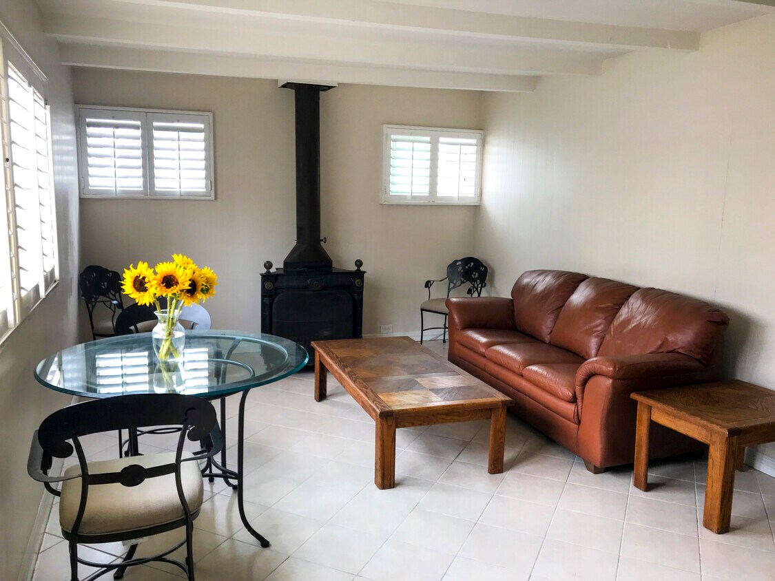 Living room with vintage fireplace, sofa bed, plantattion shutters and tile floor - 216 Onyx Ave