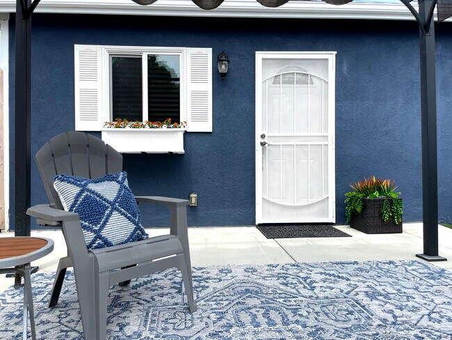 Sitting area with new rug under retractable pergola for shaded comfort - 3541 Helms Ave