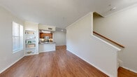 Located in Plano, TX, this two-story, one-bedroom, one-bathroom home offers a well-organized layout across two floors. The main level features an open-concept living room and kitchen, finished with warm hardwood-style flooring and crown molding throughout. The living area is bathed in natural light from a large window and flows seamlessly into the kitchen, which is equipped with rich wood cabinetry, granite-style countertops, a peninsula breakfast bar, stainless steel appliances, and a double sink. A built-in shelving unit adds functional storage near the entry. The laundry area is conveniently tucked away on the main floor with washer/dryer hookups and overhead shelving. Upstairs, the generously sized primary bedroom features plush carpet, a tray ceiling with ceiling fan, a large window overlooking lush greenery, and a sliding-door closet providing ample storage. The full bathroom is finished with wood-toned cabinetry, granite-style counters, a shower/tub combination, and hardwood-style flooring. A hallway connects the upper-level spaces efficiently. Throughout, neutral tones and consistent finishes create a cohesive, calm ambiance suited to comfortable everyday living.
