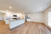 Located in Rossville, GA, this single-story home offers a thoughtfully designed layout with modern finishes throughout. The open-concept kitchen and living area serves as the heart of the home, showcasing white shaker-style cabinetry, granite countertops, a central island with a sink, stainless steel appliances including a range, microwave, and refrigerator, and recessed lighting overhead. Light-toned luxury vinyl plank flooring flows seamlessly throughout the entire residence, lending a clean and cohesive aesthetic.

The bedrooms are well-proportioned, each featuring windows with blinds that invite natural light. A spacious walk-in closet with wire shelving provides generous storage for the primary suite. The primary bathroom is equipped with a double-sink vanity topped with granite counters, white cabinetry, a large mirror, and a glass-enclosed walk-in shower. A dedicated laundry room accommodates a full-sized washer and dryer. The hallway layout, as illustrated by the floorplan, connects the rooms efficiently, maximizing livability and function across the single level. Neutral wall tones and clean trim work throughout contribute to a bright, move-in-ready atmosphere.