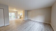 This single-floor home offers a thoughtfully designed layout accommodating four bedrooms and two full bathrooms. The open-concept living and dining area is finished with light-toned luxury vinyl plank flooring, neutral walls, and a sliding glass door that opens to a private balcony overlooking lush, tree-lined surroundings—bringing natural light and outdoor views into the living space. The kitchen is outfitted with crisp white shaker cabinets, light granite-style countertops, stainless steel appliances including a range, dishwasher, and refrigerator, plus a window above the sink for added brightness. The bedrooms feature plush carpeting and generous closet space; the primary bedroom includes a dual sliding-door closet system offering ample storage. A connecting bathroom showcases a white vanity with a modern matte black faucet, a large mirror, and direct access to an adjacent bedroom. The second bathroom provides a full tub-shower combination with clean white surrounds and matte black fixtures. Throughout the home, a consistent neutral color palette, updated finishes, and an efficient single-level floor plan create a clean, move-in-ready living environment.
