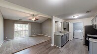 Located at 127 Patriot Dr in Bardstown, Kentucky, this 2-bedroom, 3-bathroom residence offers a well-organized single-floor layout designed for comfortable everyday living. The combined dining and living area is highlighted by vaulted ceilings, a ceiling fan, and wood-look flooring that transitions seamlessly to carpet, while a sliding glass door opens to a private balcony, bringing in generous natural light. The galley-style kitchen is well-appointed with gray shaker cabinetry, granite-look countertops, a double-basin sink, and a full suite of stainless steel appliances including a refrigerator, electric range, microwave, and dishwasher. A dedicated laundry room with a full-size washer and dryer is conveniently accessible directly from the kitchen. The spacious primary bedroom features vaulted ceilings, a ceiling fan, plush carpet, and its own balcony access via a sliding glass door. The second bedroom is equally comfortable with soft carpet and neutral gray walls. Three closets provide ample storage throughout. The bathrooms each include a full tub-shower combination with clean white surrounds and chrome fixtures. A hallway connects all rooms, contributing to a functional and cohesive floor plan throughout this Bardstown residence.