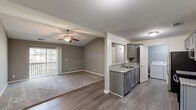 Located at 127 Patriot Dr in Bardstown, Kentucky, this 2-bedroom, 3-bathroom residence offers a well-organized single-floor layout designed for comfortable everyday living. The combined dining and living area is highlighted by vaulted ceilings, a ceiling fan, and wood-look flooring that transitions seamlessly to carpet, while a sliding glass door opens to a private balcony, bringing in generous natural light. The galley-style kitchen is well-appointed with gray shaker cabinetry, granite-look countertops, a double-basin sink, and a full suite of stainless steel appliances including a refrigerator, electric range, microwave, and dishwasher. A dedicated laundry room with a full-size washer and dryer is conveniently accessible directly from the kitchen. The spacious primary bedroom features vaulted ceilings, a ceiling fan, plush carpet, and its own balcony access via a sliding glass door. The second bedroom is equally comfortable with soft carpet and neutral gray walls. Three closets provide ample storage throughout. The bathrooms each include a full tub-shower combination with clean white surrounds and chrome fixtures. A hallway connects all rooms, contributing to a functional and cohesive floor plan throughout this Bardstown residence.