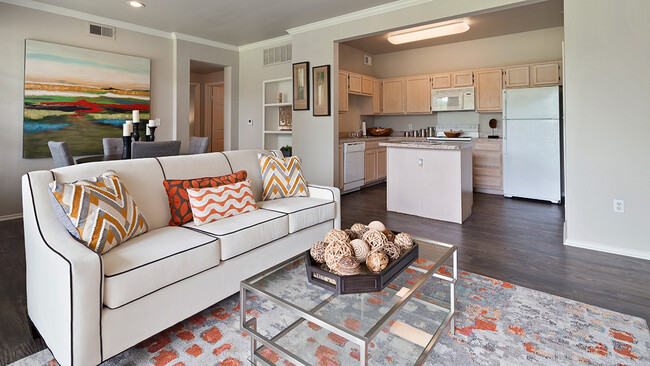 Spacious Living Room and Kitchen with Quartz Countertops, White Appliances, and Island - Legends at Chase Oaks