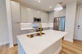 This contemporary 680 square foot apartment in Tampa, FL, offers a harmonious blend of style and functionality. The open-concept design creates a seamless flow between the living areas, maximizing the use of space. The heart of the home is the modern kitchen, boasting white cabinetry, stainless steel appliances, and a striking island with a gold faucet, perfect for both meal preparation and casual dining.

The bedroom, measuring 130 square feet, is generously sized and features large windows that flood the space with natural light. A ceiling fan adds both style and comfort. The bathroom is sleek and spacious, with a double vanity, large mirror, and a combination tub-shower.

Throughout the apartment, light-toned wood-look flooring creates a warm, inviting atmosphere, complemented by crisp white walls and baseboards. The living area is bright and airy, with multiple windows offering views and ample natural light. A well-designed closet system provides excellent storage options.

The unit's modern fixtures, including recessed lighting and stylish pendant lights in the kitchen, add to its contemporary appeal. With its thoughtful layout and high-quality finishes, this apartment offers a comfortable and stylish living space in the heart of Tampa.