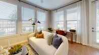 This thoughtfully designed 2-bedroom, 2-bathroom residence offers a comfortable and modern living experience across a single floor. Light-toned hardwood flooring flows seamlessly throughout, lending warmth and continuity to every room.

The open-concept kitchen is a standout feature, showcasing white shaker cabinetry, a classic subway tile backsplash, stainless steel appliances, and a large quartz-topped island with bar seating — ideal for both everyday meals and entertaining. The adjacent living room is bright and welcoming, with a bank of windows that fill the space with natural light and offer views of the surrounding outdoors.

A well-lit hallway connects the bedrooms, each offering ceiling fans, generous windows, and a calm, neutral palette. The primary bedroom is notably spacious and includes direct access to its own bathroom. Both bathrooms are finished with white vanities, clean tile work, and tub-shower combinations.

The residence includes five closets throughout, providing exceptional storage options, including a large walk-in closet with multi-tiered shelving and hanging rods. A dedicated laundry area adds everyday convenience. Recessed lighting and a consistent soft gray color scheme create a cohesive, modern ambiance throughout the entire home.
