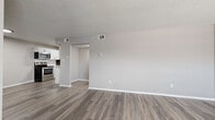 This single-floor, 1-bedroom, 1-bathroom unit offers a clean and modern living environment with thoughtfully updated finishes throughout. The open-concept living room greets you at the entry, featuring wood-look luxury vinyl plank flooring, neutral gray walls, and a textured ceiling that flows seamlessly into the adjacent kitchen and living areas. A window with blinds allows natural light to fill the space, creating a bright and welcoming atmosphere.

The galley-style kitchen is well-equipped with stainless steel appliances — including an electric range, over-the-range microwave, refrigerator, and dishwasher — complemented by white shaker cabinetry, granite-style countertops, and a classic subway tile backsplash. The layout maximizes efficiency while maintaining a polished, contemporary look.

The bedroom offers a comfortable and private retreat, highlighted by plush carpet flooring, a ceiling fan with light fixture, a window with natural light, and a double-door closet providing generous storage. A hallway connects the main living areas to the bedroom and bathroom.

The bathroom is clean and functional, featuring a full tub/shower combo, a white vanity, and wood-look flooring consistent with the rest of the unit. Throughout the space, consistent neutral tones, updated fixtures, and modern flooring choices create a cohesive and move-in-ready environment.
