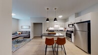 Located at 12191 Felch St in Holland, Michigan, this thoughtfully designed single-floor residence offers a contemporary open-concept layout with clean lines and modern finishes throughout. The kitchen serves as the heart of the home, showcasing white shaker-style cabinetry, dark countertops, and a full suite of stainless steel appliances including a range, microwave, and refrigerator. A central island with seating for two is accented by stylish pendant lighting, making it ideal for casual dining or entertaining. Light-toned luxury vinyl plank flooring flows seamlessly through the main living areas, adding warmth and continuity. The living area is open to the kitchen, creating an inviting and connected social space. The bedroom is a comfortable retreat featuring carpet flooring, a large window with natural light, and ample wall space. The bathroom is well-appointed with a vanity featuring under-sink storage, a framed mirror, and neutral tile flooring. Additional rooms include a flexible space well-suited as a home office or den, complete with carpeted floors, a window, and built-in storage access. The overall aesthetic is clean, modern, and functional, offering a balanced living environment in a residential Holland neighborhood.