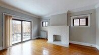 Located at 2773 Hampshire Rd in Cleveland Heights, Ohio, this one-bedroom, one-bathroom unit offers a thoughtful layout across a single floor. Warm hardwood floors run throughout the space, complementing the neutral gray walls and crisp white trim found in every room.

The living room serves as the focal point of the unit, featuring a striking white-painted brick fireplace, elegant crown molding, and multiple windows that allow natural light to fill the space. A sliding glass door provides direct access to a private balcony with neighborhood views, adding an inviting indoor-outdoor connection.

The kitchen has been tastefully updated with white shaker cabinetry, marble-look countertops, and black appliances including a dishwasher, electric range, and a stainless steel refrigerator. Crown molding and hardwood floors continue here, tying the space together cohesively.

The bedroom is a well-proportioned retreat with dual windows that bring in ample natural light, hardwood floors, and a cast iron radiator. Three closets throughout the unit offer generous storage.

The bathroom features a full tub-shower combination with white tile surround, beadboard wainscoting, and a window for ventilation. A connecting hallway ties all rooms together efficiently, rounding out this classic yet well-appointed Cleveland Heights residence.