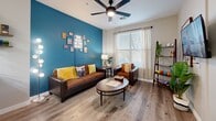 This 530 square foot apartment in Tucson, Arizona, offers a thoughtfully designed living space that maximizes functionality and style. The open-concept floor plan seamlessly integrates the kitchen, living room, and dining area, creating a sense of spaciousness. The kitchen boasts sleek white cabinetry, stainless steel appliances, and granite countertops, providing both aesthetic appeal and practicality.

The living area features a vibrant teal accent wall, adding a pop of color and personality to the space. Large windows allow ample natural light, while the wood-look flooring throughout adds warmth and durability. The bedroom, measuring 130 square feet, offers a cozy retreat with stylish decor and sufficient space for a queen-sized bed.

The bathroom is well-appointed with modern fixtures, including a combination tub and shower, and incorporates touches of greenery for a fresh feel. Throughout the apartment, clever storage solutions and multi-functional furniture pieces help maximize the available space. Ceiling fans and contemporary lighting fixtures enhance comfort and ambiance. This compact yet efficiently designed apartment offers a perfect blend of style and functionality for urban living.