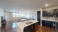 Located at 1501 Meridian Dr in Irving, TX, this one-bedroom, one-bathroom residence offers a thoughtfully designed open-concept layout across a single floor. The combined kitchen and living area serves as the heart of the home, featuring rich hardwood-style flooring, recessed lighting, and a ceiling fan. The kitchen is well-appointed with dark espresso cabinetry, white quartz countertops, a subway tile backsplash, stainless steel appliances, and a central island with a single-basin sink and bar seating — ideal for both cooking and casual dining. Ample upper and lower cabinetry provides generous storage throughout. An in-unit washer and dryer area is conveniently tucked nearby. The living area is bright and airy, bathed in natural light from a trio of large windows dressed with classic white blinds. The bedroom continues the warm, neutral palette with plush carpeting, multiple windows, and a ceiling fan. It connects directly to a walk-in closet outfitted with built-in shelving and hanging rods for organized storage. The bathroom features dark wood cabinetry, a white countertop vanity, and a clean, modern aesthetic with wood-style flooring that flows seamlessly through the space.