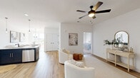 This single-story, 2-bedroom, 2-bathroom home at 425 Pea Ridge Rd in Clarksville, TN offers a thoughtfully designed open-concept layout that connects the living room, dining area, and kitchen into a cohesive, comfortable living space. The living room features warm wood-look flooring, a ceiling fan with light, and bright white walls that create an airy, welcoming ambiance. The adjacent dining area is accented by an elegant chandelier with seeded glass shades, adding a refined touch. The kitchen is a standout, showcasing dark navy shaker-style cabinetry, white quartz countertops, a subway tile backsplash, stainless steel appliances, and recessed lighting — a stylish and functional space for cooking and entertaining. Both bathrooms continue the modern aesthetic with matching navy vanities, white countertops, wood-look tile flooring, and tub-shower combinations with black hardware accents. The spacious primary bedroom features soft carpet flooring, a ceiling fan, and a private door with outdoor access. The second bedroom also offers plush carpeting and a ceiling fan. A dedicated laundry room with side-by-side washer and dryer hookups and overhead shelving adds everyday convenience. Two closets provide ample storage throughout the home.