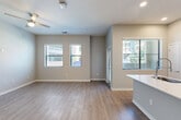 Located at 14965 W Encanto Blvd in Goodyear, AZ, this well-appointed 1-bedroom, 2-bathroom residence offers a thoughtfully designed single-level layout with modern finishes throughout. The open-concept living area features warm wood-look flooring, neutral gray walls, a ceiling fan, and multiple windows dressed with blinds that invite natural light while maintaining privacy.

The kitchen is a standout feature, showcasing a large white quartz island with an undermount sink and professional-style faucet, crisp white shaker cabinetry, a herringbone tile backsplash, and a full suite of stainless steel appliances including a refrigerator, range, microwave, and dishwasher. A stacked washer and dryer unit is conveniently integrated nearby.

The spacious primary bedroom is finished with plush carpet, vaulted ceilings, a ceiling fan, and a natural light window. It includes direct access to a well-organized closet with built-in shelving and hanging rods, as well as a private en-suite bathroom. Both bathrooms are elegantly finished with white quartz vanities, black hardware accents, LED-lit mirrors, and large-format gray tile surrounds in the tub-shower combinations. Light wood-look flooring ties the bathrooms together with the rest of the home's cohesive aesthetic.