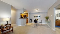 Located at 4475 Heritage Ave in Okemos, Michigan, this single-floor residence offers a well-organized layout with a comfortable, neutral aesthetic throughout. The living room serves as the heart of the home, featuring plush carpeting, a textured ceiling, and a large sliding glass door framed by vertical blinds that floods the space with natural light and provides outdoor views. The open-concept design connects the living area to a dedicated dining space, separated from the kitchen by a half-wall pass-through that enhances the sense of openness. The galley-style kitchen is efficiently designed with warm oak cabinetry, granite-look countertops, wood-look vinyl flooring, and black appliances including a refrigerator, range, and built-in microwave. Two bedrooms offer carpeted floors, neutral wall tones, and natural light from windows with blinds. One bedroom features an en suite bathroom with a vanity, granite-look counters, and a tub-shower combination, while a second full bathroom mirrors the same warm finishes with wood-look flooring. A dedicated in-unit laundry room provides added convenience, housing a full-size washer and dryer alongside built-in shelving and an electrical panel. The overall ambiance is clean, functional, and move-in ready.