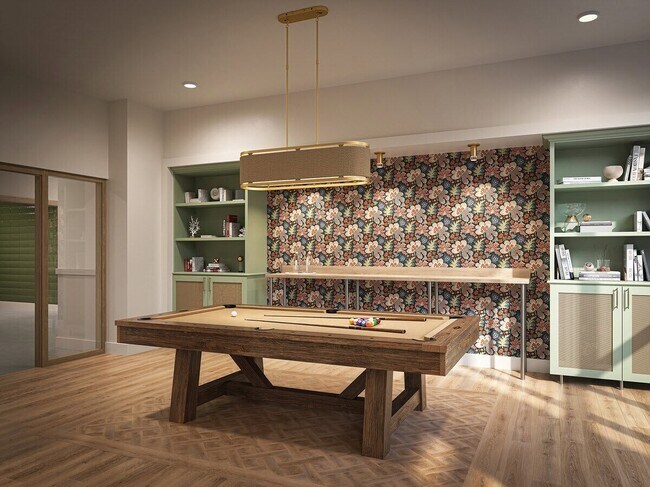 Sala común para residentes con mesa de billar, acabados modernos y espacio de reunión. - Trail House Apartments