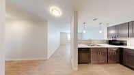 Located at 400 Willis Avenue in Rochelle, IL, this single-floor, 2-bedroom, 2-bathroom residence offers a clean, modern design with a cohesive neutral palette and light wood-style flooring carried throughout. The open-concept kitchen and living area serves as the heart of the home, where a well-equipped kitchen features dark espresso cabinetry, light marble-style countertops, a double-basin sink, black appliances including a gas range and dishwasher, a tile backsplash, and pendant lighting. A half-wall peninsula separates the kitchen from the living area, creating a functional yet connected layout. Natural light filters in through windows fitted with horizontal blinds, contributing to the bright, airy atmosphere present across the entire residence. The hallway connects the main living areas to both bedrooms and bathrooms, maintaining an efficient and logical flow. The primary bedroom offers comfortable proportions, including a walk-in closet with built-in shelving and hanging rods. The second bedroom also features a window with natural light and ample floor space. Both bathrooms are finished in a clean, contemporary style. Throughout the residence, white trim, flush-mount and pendant light fixtures, and consistent flooring create a unified, move-in-ready aesthetic.