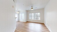 This well-appointed one-bedroom, two-bathroom residence offers a thoughtfully designed single-floor layout that maximizes functionality and comfort. Throughout the main living areas, light-toned hardwood flooring creates a clean, cohesive aesthetic that reflects an abundance of natural light streaming in through large windows fitted with vertical blinds.

The open-concept kitchen and living room serves as the heart of the home. The living area features a ceiling fan with a brushed gold finish and dual windows that bathe the space in natural light, creating an airy, welcoming atmosphere. A pendant light marks the transition to the kitchen, which is defined by a pass-through breakfast bar. The kitchen is equipped with white cabinetry offering ample storage, light countertops, a full suite of white appliances including a refrigerator, dishwasher, microwave, and stove, and a stainless steel sink.

The bedroom is a serene retreat featuring plush carpeting, bright white walls, and direct access to one of the two bathrooms. This bathroom includes a single vanity, toilet, and a full soaking tub with tiled surround. A dedicated closet adjoins the bedroom for additional storage.

A separate laundry room houses a washer and water heater, adding everyday convenience. The second bathroom provides additional functionality for guests. Clean lines, neutral tones, and an efficient layout define this well-organized residence.