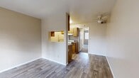 Located at 1538 W Thornhill Dr in Taylorsville, Utah, this one-bedroom, two-bathroom residence offers a practical and well-organized single-floor layout. The open living area features wood-style plank flooring and neutral warm-toned walls, creating a clean and inviting atmosphere. A ceiling fan overhead adds comfort, while French doors provide access to a private balcony, allowing for natural light to fill the space. The kitchen is defined by warm wood-toned cabinetry and connects to the living and dining area through a distinctive pass-through window cutout, lending an open feel without fully removing the separation between spaces. The bedroom is carpeted for added comfort and includes a window with blinds that brings in natural light. The closet offers dedicated storage space. One bathroom features a full soaking tub with a shower fixture and smooth surround panels, while a second bathroom includes a vanity with granite-style countertops, under-sink cabinetry, a mirrored medicine cabinet, and wood-style flooring. Notably, the second bathroom area also accommodates an in-unit stacked washer, adding everyday convenience. Throughout the residence, the design is straightforward and functional, with consistent finishes that create a cohesive, move-in-ready environment.