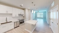 Located at 504 Jordan Pl in Charlotte, NC, this 2-bedroom, 1-bathroom home offers a thoughtfully designed single-floor layout with modern finishes throughout. The open-concept kitchen serves as the heart of the home, featuring crisp white cabinetry, a light stone countertop island with pendant lighting overhead, stainless steel appliances including a refrigerator and range, and light hardwood-style flooring that extends into the adjacent living area. Recessed lighting adds a clean, contemporary feel to the kitchen and living space, which is brightened further by a large window with natural light.

The bedrooms are carpeted for comfort and include windows with blinds that bring in natural light. The primary bedroom features a ceiling fan and access to a walk-in closet with wire shelving for organized storage. The second bedroom offers a cozy, quiet retreat with its own window.

The bathroom is finished with a white vanity with stone countertops, sleek hardware, a large mirror with overhead lighting, light wood-look tile flooring, and a glass-enclosed shower. Neutral, warm-toned walls flow consistently throughout the home, creating a cohesive and calm aesthetic that is both functional and inviting.