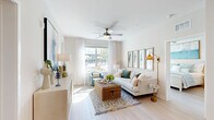 Located at 1153 Bees Ferry Rd on Johns Island, SC, this well-appointed 2-bedroom, 3-bathroom residence offers a thoughtfully designed single-floor layout with a bright, coastal aesthetic. The open-concept kitchen and living area serves as the heart of the home, anchored by a white quartz waterfall island with seating for multiple guests. The kitchen features warm natural wood cabinetry, open shelving, a white subway tile backsplash, stainless steel appliances, and pendant lighting. Light wood-tone flooring flows seamlessly throughout the space, enhancing the airy feel.

The living room is bathed in natural light from large windows with sheer curtains and is finished with a ceiling fan overhead. Outdoor views add a pleasant sense of connection to the surrounding community.

The primary bedroom is a well-sized retreat with large windows, a ceiling fan, and access to a dedicated closet. The primary bathroom offers a dual-sink vanity with wood cabinetry, quartz countertops, a glass-enclosed shower, and a walk-in closet with built-in wire shelving systems. The second bedroom is equally bright, with generous window exposure and a ceiling fan.

Two additional closets provide practical storage throughout. The overall ambiance is clean, modern, and inviting, with a cohesive coastal palette of whites, naturals, and soft blues.