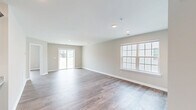 Located at 720 Charter Dr in Longs, SC, this single-story, 3-bedroom, 2-bathroom home offers a clean and functional layout with consistent wood-look flooring throughout. A welcoming hallway with recessed lighting and arched panel doors connects the bedrooms and living spaces with ease.

The kitchen is a standout feature, showcasing rich dark cabinetry, granite-style countertops, stainless steel appliances including a refrigerator, range, and built-in microwave, and a deep undermount sink — all finished with warm wood-look flooring that ties the space together.

The open living room is bright and airy, with large windows and a sliding glass door that invites natural light and provides access to the outdoors. Neutral toned walls and recessed lighting create a versatile, move-in-ready environment.

The generously sized primary bedroom offers a comfortable retreat with natural light from a large window. The two additional bedrooms are well-proportioned, each featuring windows that bring in outdoor light. Both bathrooms are outfitted with dark vanity cabinetry, white countertops, and tub-shower combinations. Two closets provide practical storage throughout the home. The overall aesthetic is clean, modern, and understated, suited for comfortable everyday living.