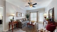 This thoughtfully designed single-floor residence offers two bedrooms and two bathrooms within a comfortable and efficiently laid-out floor plan. The inviting living room features crown molding, hardwood-style flooring, and a ceiling fan with light fixture. Natural light flows in through large windows with white plantation shutters, and a glass-paneled exterior door provides additional brightness and outdoor access. The dining area is a standout architectural feature, boasting a tray ceiling with a chandelier and elegant white decorative columns that frame the space beautifully. The kitchen is well-equipped with stainless steel appliances, including a range, microwave, and dishwasher, complemented by white cabinetry and granite-style countertops over tile flooring. The primary bedroom offers generous space with hardwood-style floors, a walk-in closet with wire shelving, and a ceiling fan. The en-suite bathroom includes granite countertops, a vanity with mirror, and a tub-shower combination with tile surround. The second bedroom similarly features a ceiling fan and convenient closet access. Two dedicated closets throughout the home provide ample storage. The overall ambiance is warm and classic, with consistent finishes that lend cohesion across the entire residence.